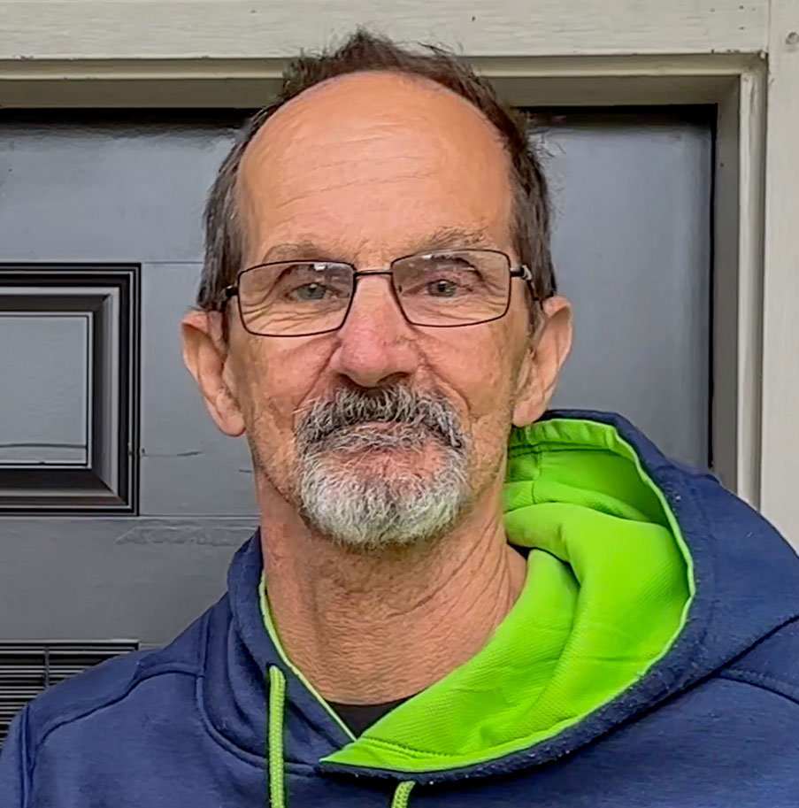 Larry in front of his home