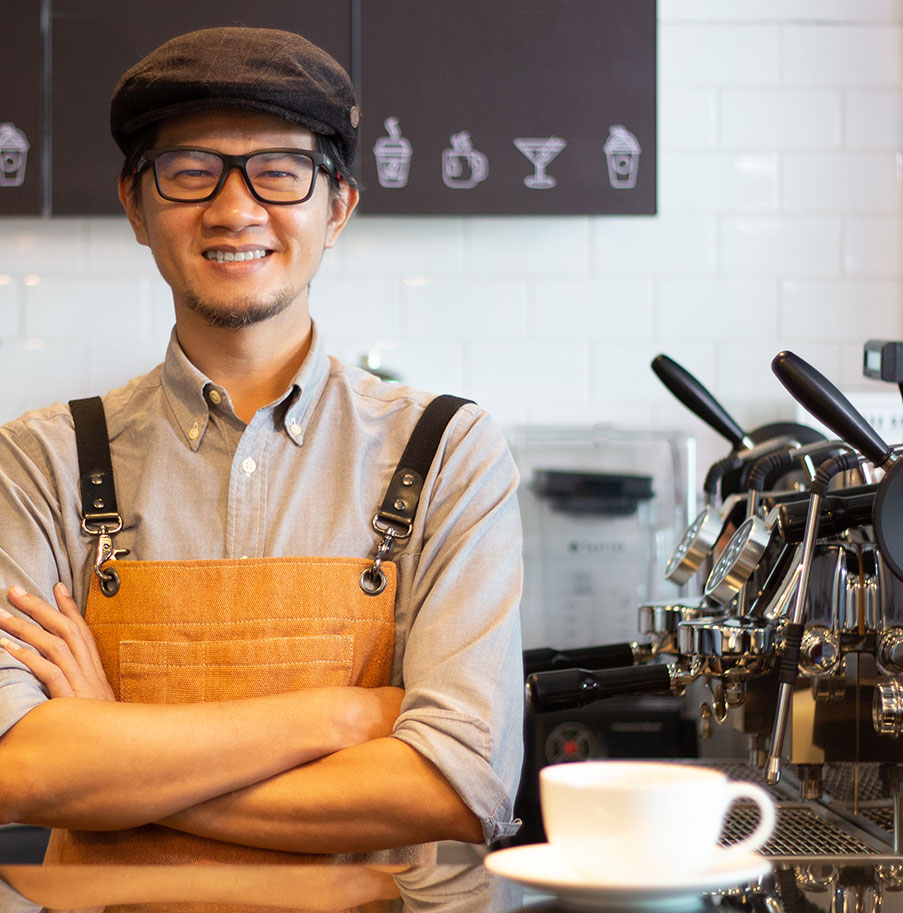 A barista smiling with a cup of coffee