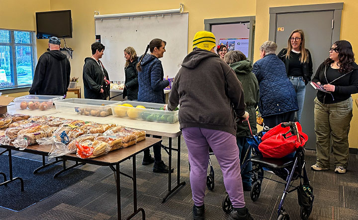 Residents gather to get grocery items as part of the monthly "Extra Helping" activity available to all CCH residents