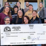 Down To Earth presing the fundraising check to