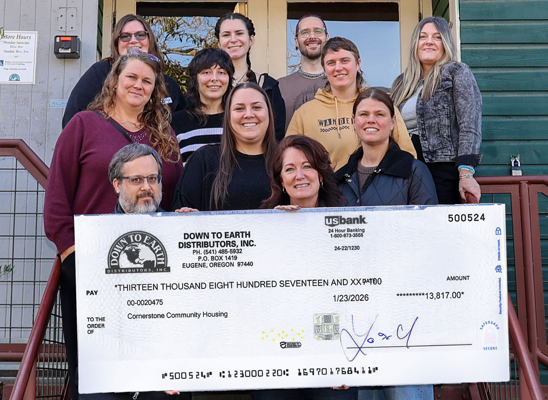 Down To Earth presing the fundraising check to